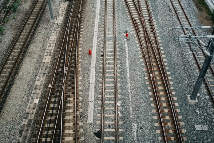 a couple of people standing on top of train tracks