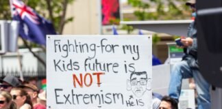 La Radicalización del Discurso Político: Cuando la Retórica Cruza Líneas Rojas a man holding a sign that says fighting for my kids future is not extre