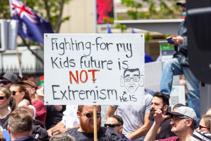 image_1770969627587 a man holding a sign that says fighting for my kids future is not extre