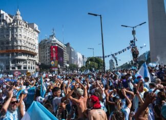 Argentina enfrenta un desafío inflacionario persistente que pone a prueba las políticas económicas actuales Argentinians celebrate in a bustling city square.