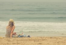 Transformación Personal en Verano: Estrategias Científicas para Renovar tu Bienestar Emocional woman sitting on seashore
