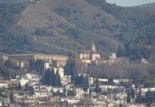 Granada destaca en los reconocimientos del Día de Andalucía con tres distinguidos galardonados A cityscape with buildings and mountains in the background.