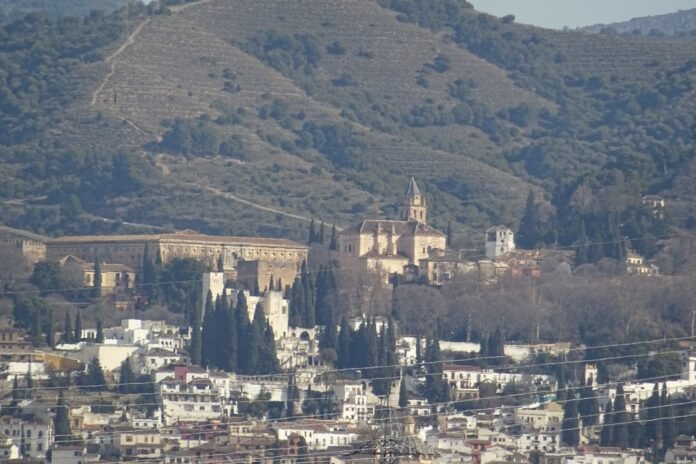 A cityscape with buildings and mountains in the background.