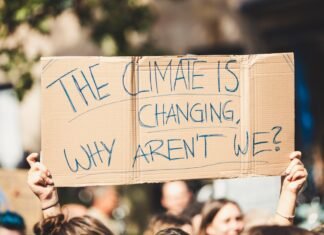 El Cambio Climático Transforma las Alergias: Cómo el Polen se Ha Vuelto un Problema de Salud Pública Prolongado a group of people holding a sign that says the climate is changing why aren '