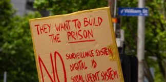 La Dependencia de las Subvenciones: ¿Frena o Impulsa el Futuro del Vehículo Eléctrico? a person holding a sign that says they want to build the prison