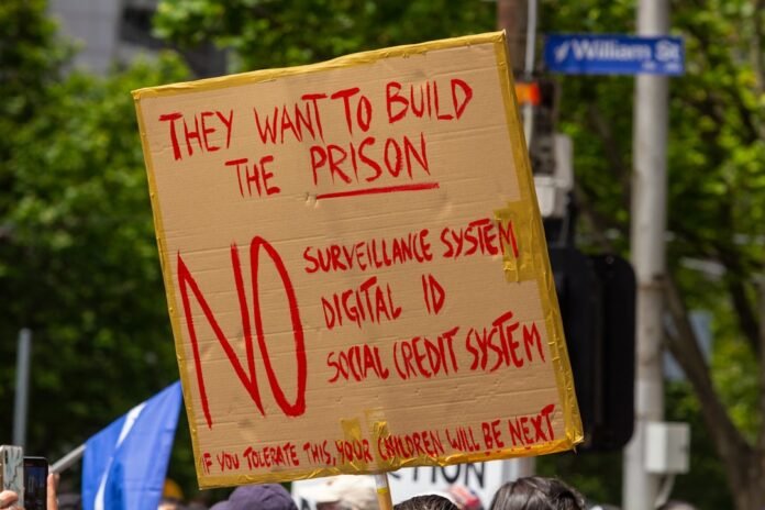 a person holding a sign that says they want to build the prison