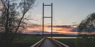 El emprendimiento como puente hacia una integración laboral exitosa de inmigrantes en España a wooden bridge with a sunset in the background