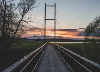 El emprendimiento como puente hacia una integración laboral exitosa de inmigrantes en España a wooden bridge with a sunset in the background