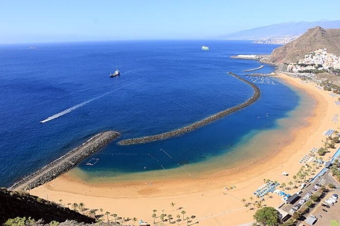 An aerial view of a beach with a boat in the water
