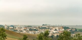 El panorama político andaluz se reconfigura: PP mantiene ventaja pero pierde hegemonía absoluta a view of a small town from a hill