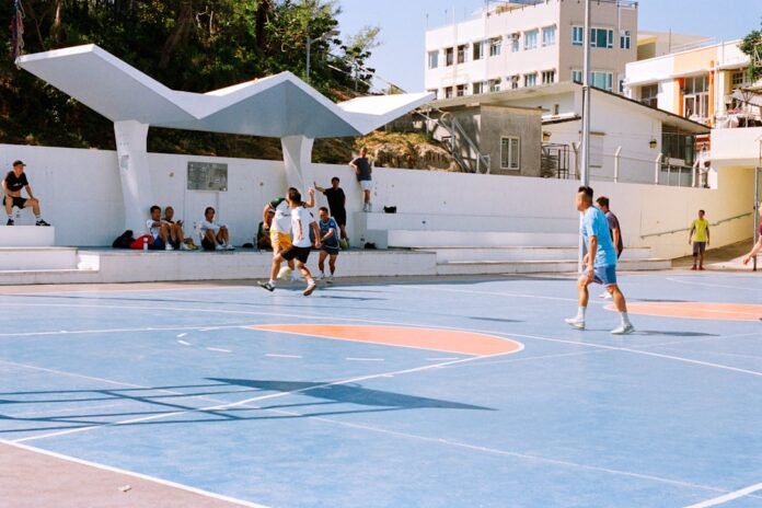 People playing basketball on an outdoor court.
