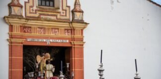 El turismo de Semana Santa alcanza cifras récord: las reservas se disparan un 25% respecto al año anterior A procession is passing in front of a church.