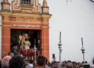 El turismo de Semana Santa alcanza cifras récord: las reservas se disparan un 25% respecto al año anterior A procession is passing in front of a church.
