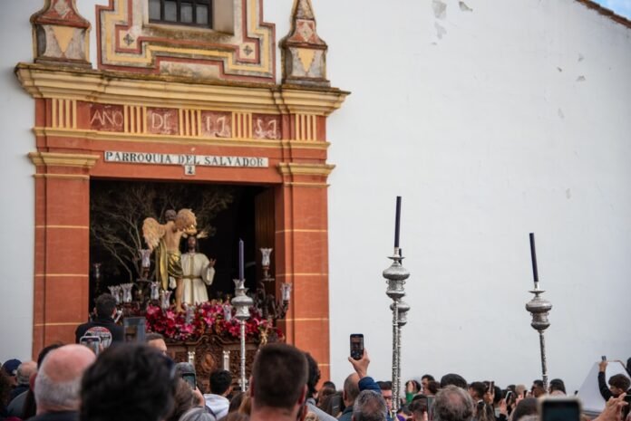 A procession is passing in front of a church.