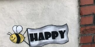 La Búsqueda de la Felicidad Auténtica: Más Allá del Éxito Material y las Experiencias Superficiales a sign that says happy with a bee on it