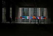 La Diplomacia Bilingüe de Marco Rubio Marca un Nuevo Capítulo en las Relaciones Hemisféricas a group of flags hanging from the side of a building