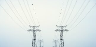 La Volatilidad Energética Global: Cuando los Mercados Anticipan Escenarios Extremos A couple of power poles sitting in the middle of a body of water