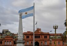 El turismo uruguayo en transformación: desafíos y oportunidades tras la temporada estival Argentinian flag waving near a prominent building.