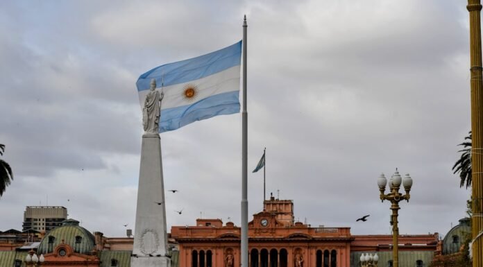 El turismo uruguayo en transformación: desafíos y oportunidades tras la temporada estival Argentinian flag waving near a prominent building.