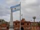 El turismo uruguayo en transformación: desafíos y oportunidades tras la temporada estival Argentinian flag waving near a prominent building.