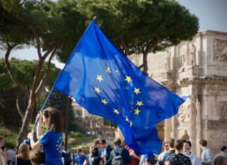 La vulnerabilidad económica de Europa ante la escalada de tensiones en Oriente Próximo a young girl holding a european flag in front of a crowd of people