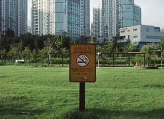 El desafío demográfico del Parque Natural de Cazorla: cuando la conservación se enfrenta al despoblamiento rural No smoking sign in a grassy park with buildings behind.