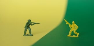 El sector de defensa español en el punto de mira: tensiones laborales por las alianzas estratégicas internacionales a toy soldier holding a gun next to a toy soldier