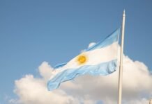 La ciencia forense argentina que trasciende fronteras: cuatro décadas devolviendo identidad a las víctimas a flag flying in the wind with a clock tower in the background