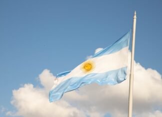 La ciencia forense argentina que trasciende fronteras: cuatro décadas devolviendo identidad a las víctimas a flag flying in the wind with a clock tower in the background