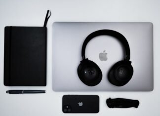 Apple Business Essentials desembarca en España: la apuesta de Cupertino por el mercado empresarial ibérico an apple laptop with headphones and a notebook