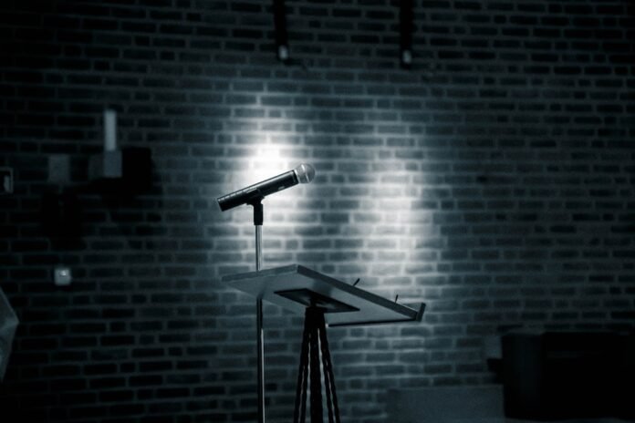 image_1774684828059 a microphone on a stand in front of a brick wall