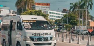 Sector del Transporte y Gobierno Alcanzan Acuerdo Provisional tras Intensas Negociaciones A white passenger van driving on a street.