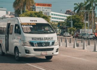 Sector del Transporte y Gobierno Alcanzan Acuerdo Provisional tras Intensas Negociaciones A white passenger van driving on a street.