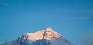El Dilema del Everest: Entre la Seguridad de los Montañistas y los Intereses Económicos de Nepal Snowy mountain peak lit by the sun.