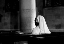 El papel de la mujer en la Iglesia Católica: entre tradición y modernidad en el siglo XXI grayscale photography of woman wearing veil sitting on bench