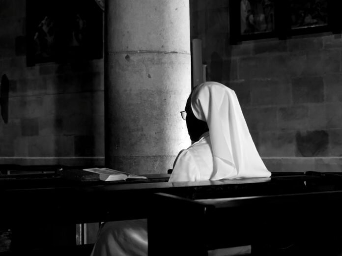 image_1775383229334 grayscale photography of woman wearing veil sitting on bench
