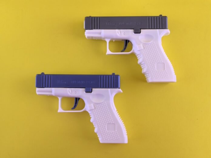 Two white and blue toy guns on a yellow background