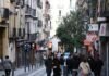 El mercado laboral español muestra fortaleza ante la incertidumbre geopolítica internacional a group of people walking down a street next to tall buildings