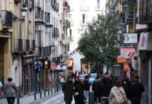 El mercado laboral español muestra fortaleza ante la incertidumbre geopolítica internacional a group of people walking down a street next to tall buildings