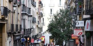 El mercado laboral español muestra fortaleza ante la incertidumbre geopolítica internacional a group of people walking down a street next to tall buildings