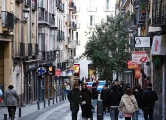 El mercado laboral español muestra fortaleza ante la incertidumbre geopolítica internacional a group of people walking down a street next to tall buildings