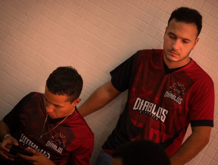 image_1775826035862 Two men in matching red and black jerseys leaning together.