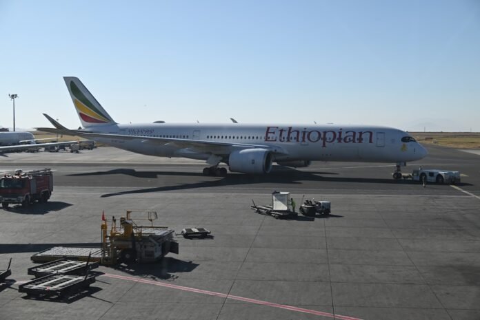 Ethiopian airlines airplane parked on tarmac at airport.