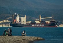 La revolución de la carga ultrarrápida: beneficios y desafíos de los 9 minutos de autonomía completa A group of people sitting on a rock next to a body of water