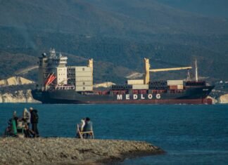 La revolución de la carga ultrarrápida: beneficios y desafíos de los 9 minutos de autonomía completa A group of people sitting on a rock next to a body of water