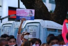 Listas de espera sanitarias: el eterno desafío político que marca el debate electoral andaluz a group of people holding signs
