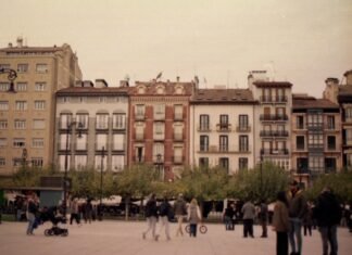 Huelga en gasolineras españolas amenaza con complicar los desplazamientos del puente de mayo People walking in a plaza with historic buildings