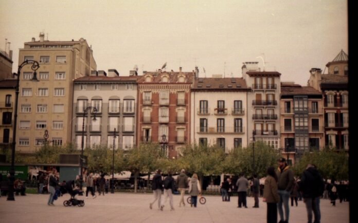 People walking in a plaza with historic buildings