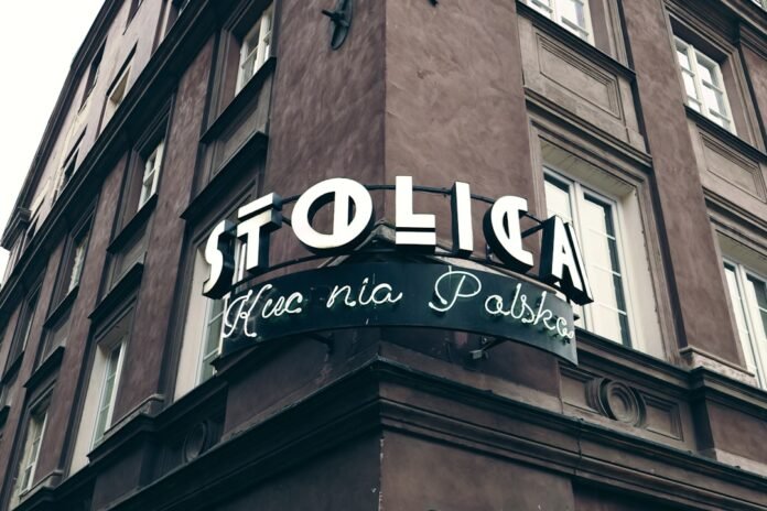 A tall brown building with a sign on the side of it