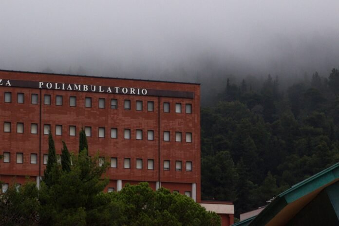 A red brick building with a forest in the background